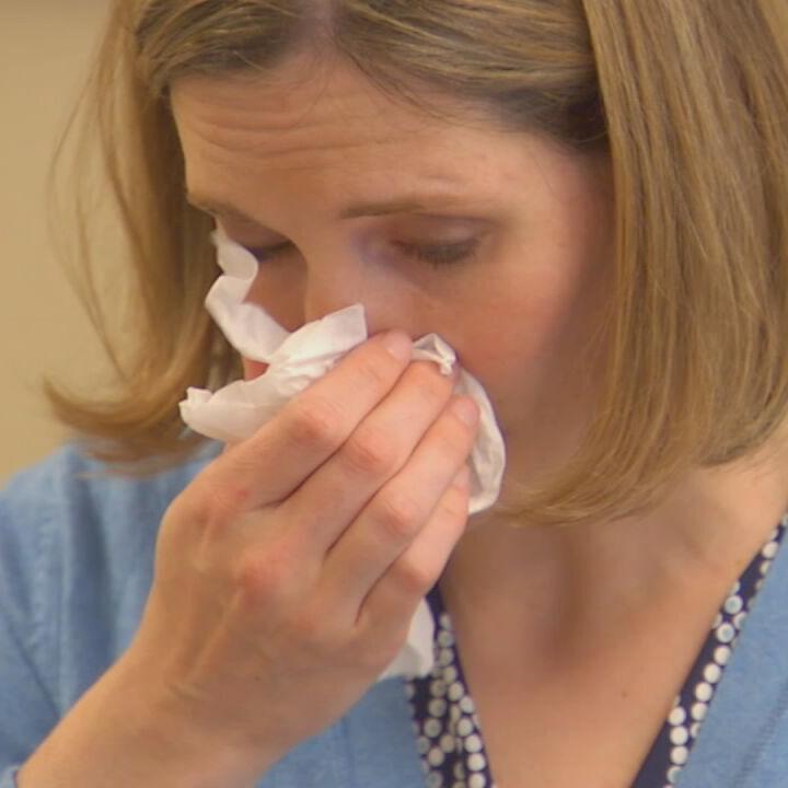 Woman blowing her nose